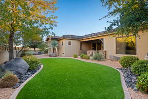 Rear view of property with stucco siding, a tile roof, and a patio