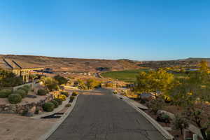 View of asphalt road featuring curbs, a mountain view, and sidewalks