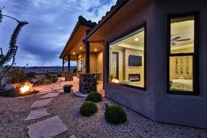 View of home's exterior with an outdoor fire pit, a patio, and stucco siding