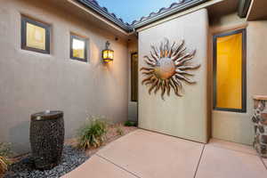 Property entrance with stucco siding and a patio