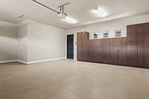 Garage with baseboards and a garage door opener