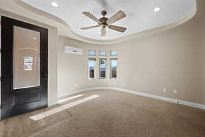 Entryway featuring a raised ceiling, carpet, ceiling fan, recessed lighting, and a wall mounted air conditioner