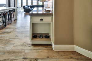 Kitchen view of light wood finished floors, cream cabinetry, and a kitchen breakfast bar
