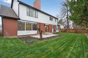 Back of property with brick siding and a chimney