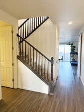 Staircase featuring wood finished floors and recessed lighting