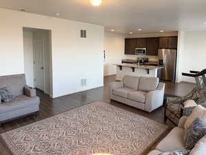 Living area with recessed lighting and dark wood-type flooring