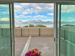 Doorway with a water and mountain view, hardwood / wood-style flooring, and plenty of natural light
