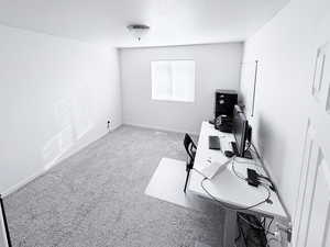 Carpeted office with baseboards and a textured ceiling