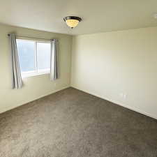 Spare room featuring baseboards and carpet