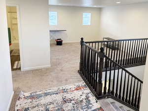 Staircase with carpet flooring and recessed lighting