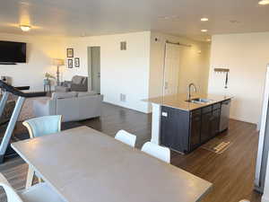 Dining area featuring a barn door, dark wood finished floors, and recessed lighting