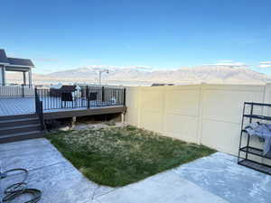 Fenced backyard with a deck with mountain view