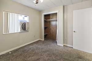 Unfurnished bedroom with carpet and a closet
