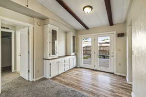 Doorway featuring beamed ceiling and carpet