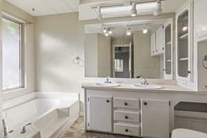 Full bathroom with a bath, double vanity, and ceiling fan