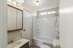 Full bathroom with vanity, shower / bathtub combination, and dark tile patterned floors