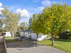 View of front of property featuring a front yard and a wooden deck