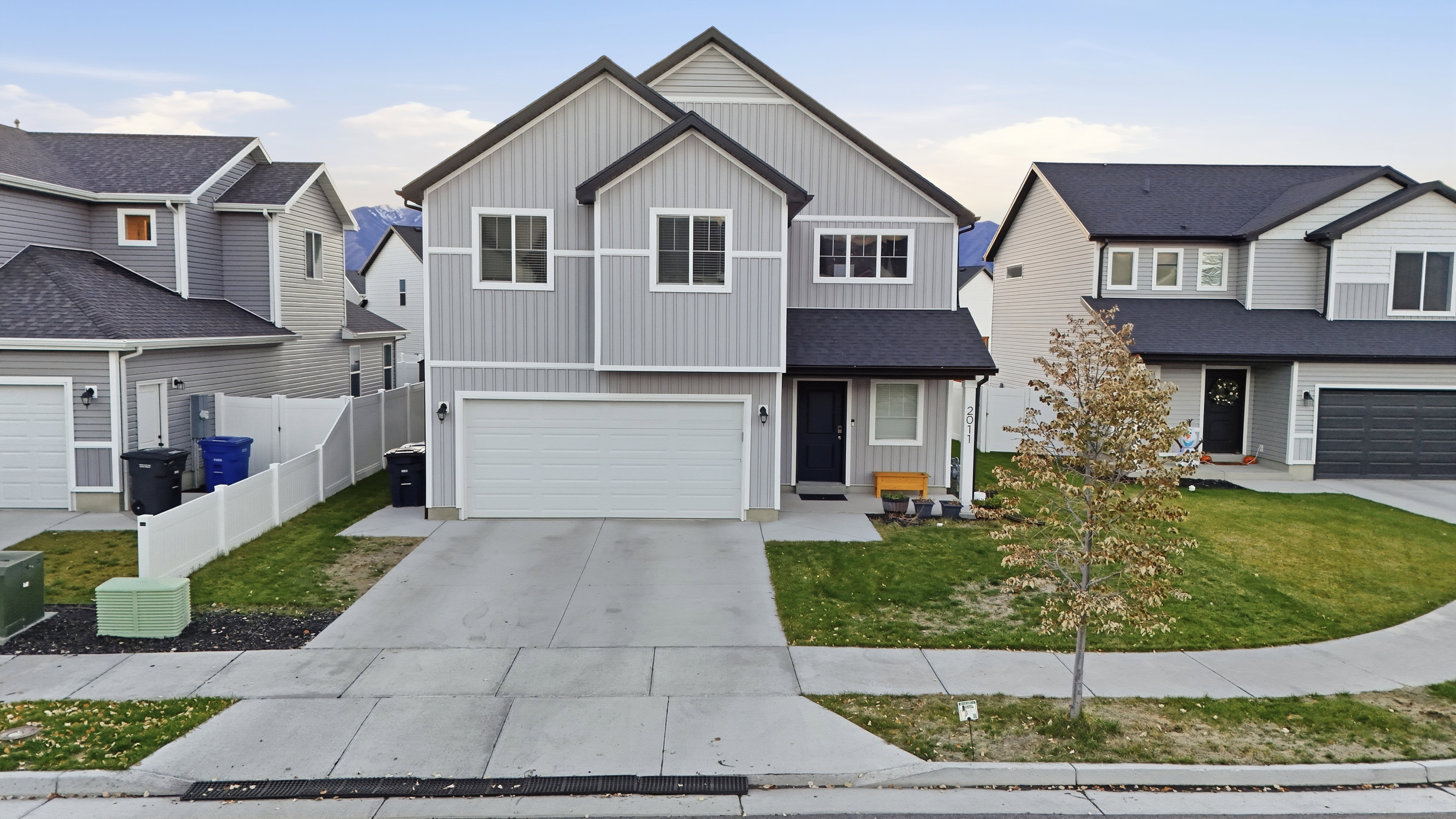 Traditional-style home featuring board and batten siding, an attached garage, and driveway