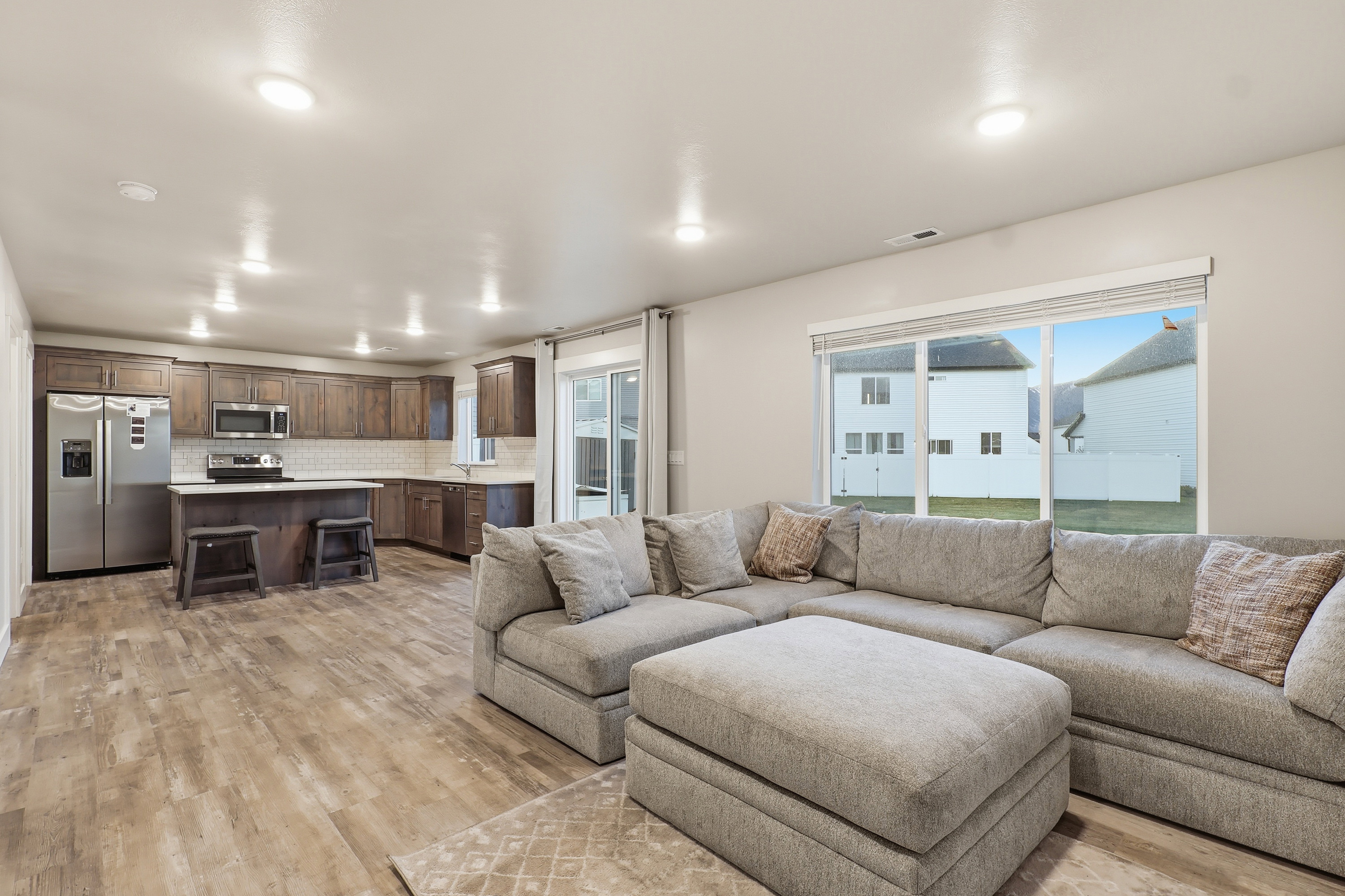 Living area with light wood finished floors and recessed lighting
