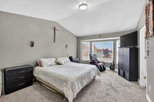 Master Bedroom with light carpet, vaulted ceiling, and closet