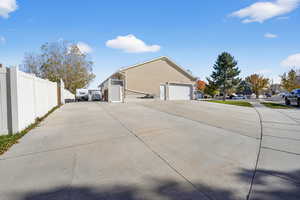 View of side of home with concrete driveway, stucco siding, and a garage