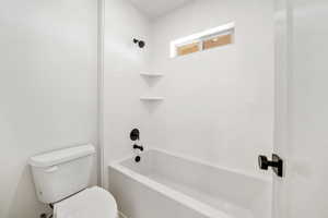 Bathroom featuring shower / bath combination and toilet