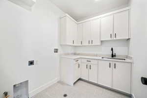 Laundry room with hookup for a washing machine, cabinet space, and hookup for an electric dryer