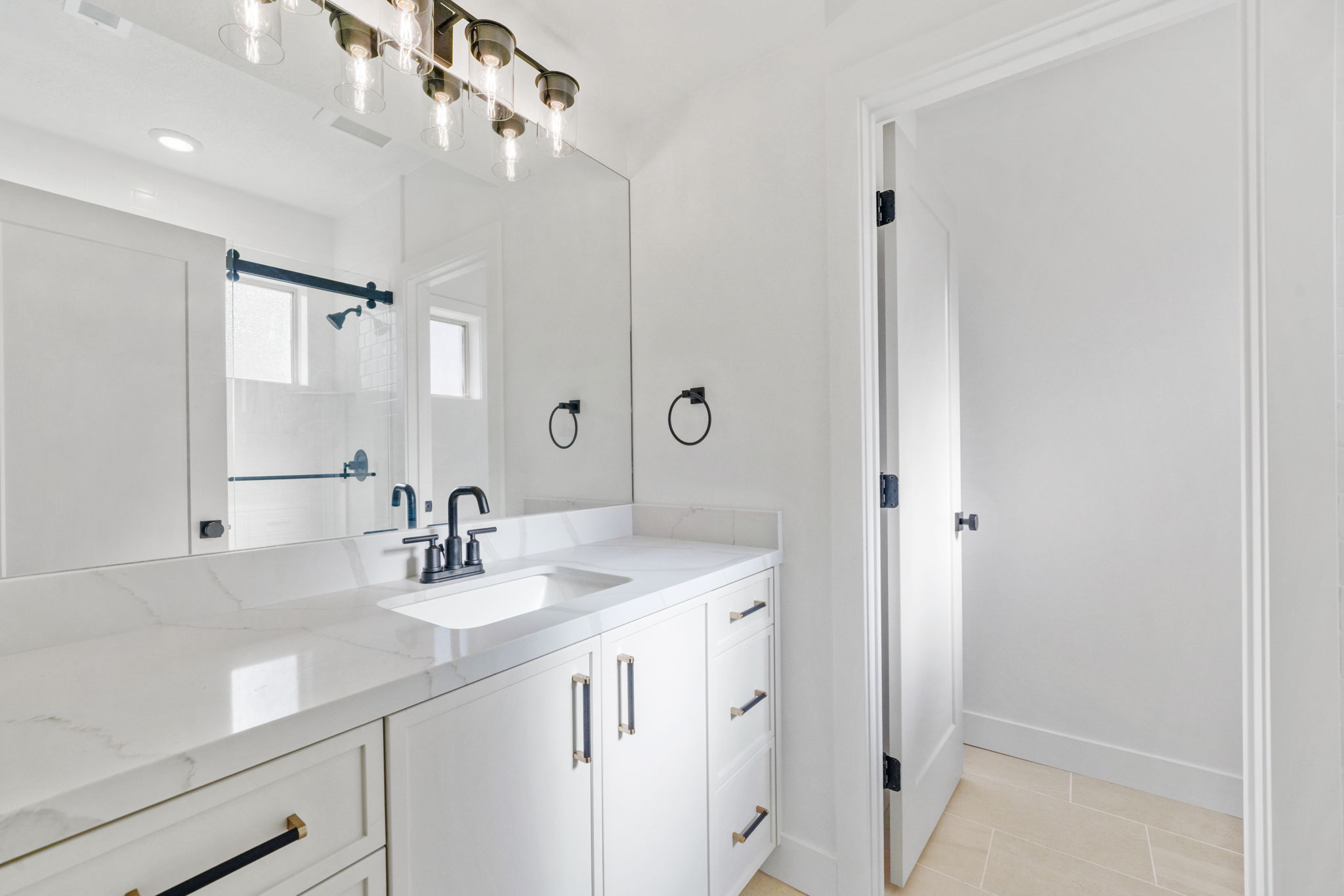 Bathroom featuring vanity, light tile patterned flooring, and a shower stall