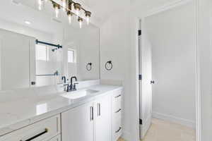 Bathroom featuring vanity, light tile patterned flooring, and a shower stall