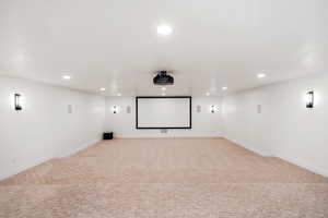 Home theater with light carpet and recessed lighting