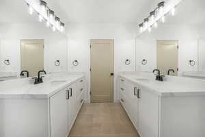 Full bath with two vanities and light tile patterned floors