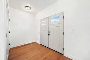 Foyer entrance with baseboards and light wood-type flooring