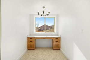 Unfurnished office featuring baseboards and a chandelier