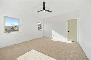 Carpeted spare room with baseboards and ceiling fan