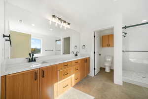 Full bath with double vanity, recessed lighting, light tile patterned flooring, and a stall shower