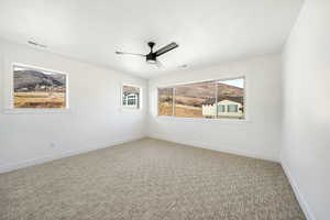 Carpeted empty room with a textured ceiling and ceiling fan