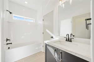 Bathroom with vanity, light tile patterned floors, and shower / bathtub combination