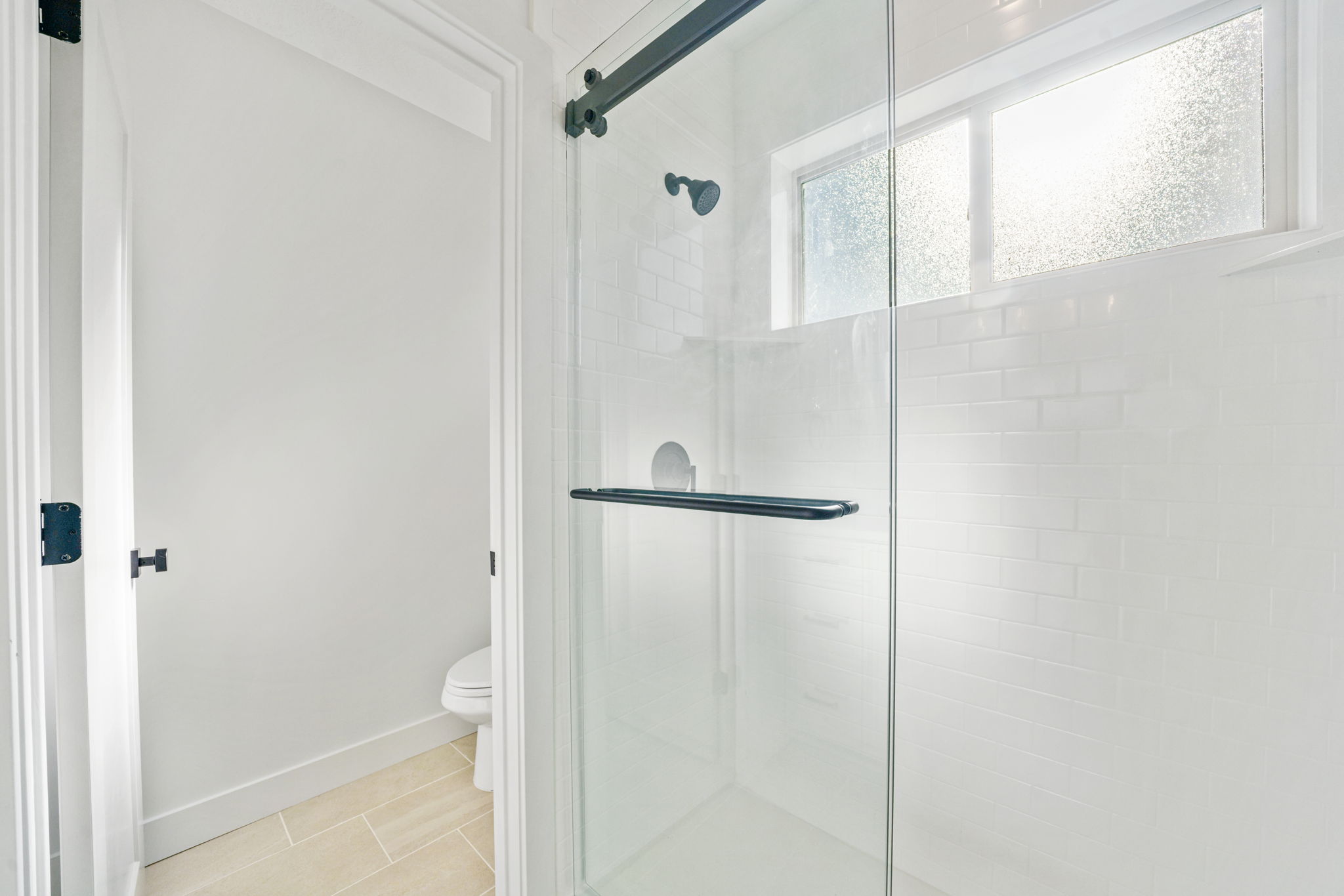 Bathroom with a shower stall and tile patterned flooring