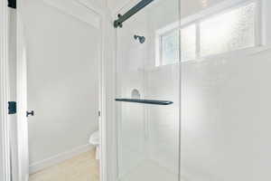 Bathroom with a shower stall and tile patterned flooring