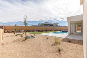 View of pool with a patio area, a fenced backyard, and a pool with connected hot tub