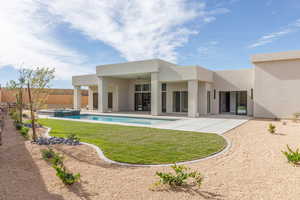 Rear view of property featuring a ceiling fan, a patio area, stucco siding, a pool with connected hot tub, and a fenced backyard