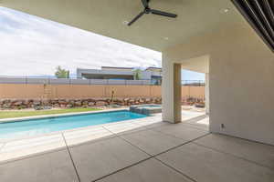 View of swimming pool with a patio, ceiling fan, a fenced backyard, and a pool with connected hot tub