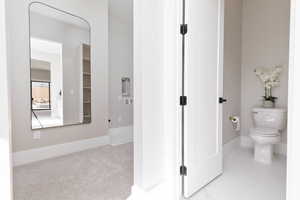 Bathroom featuring baseboards and toilet