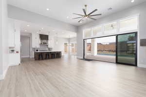 Unfurnished living room featuring recessed lighting, a chandelier, a ceiling fan, and light wood-style flooring