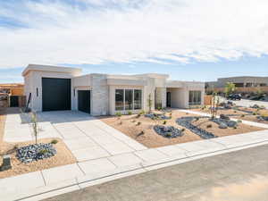 Modern home with stone siding, stucco siding, driveway, and an attached garage