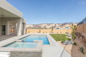 View of pool featuring a patio, a mountain view, a fenced backyard, and a pool with connected hot tub