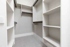 Spacious closet featuring light colored carpet