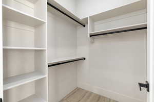 Walk in closet with light wood-type flooring