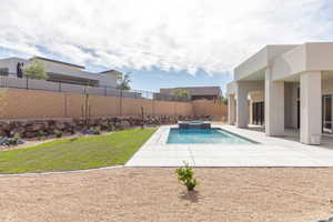 View of swimming pool with a patio area, a fenced backyard, and a pool with connected hot tub