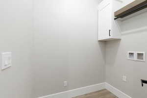 Laundry room featuring cabinet space, washer hookup, and light wood-type flooring